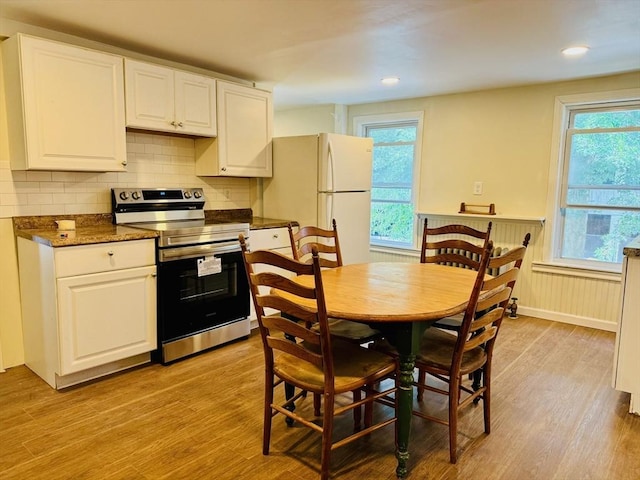 kitchen featuring light wood-type flooring, white cabinets, electric stove, and freestanding refrigerator