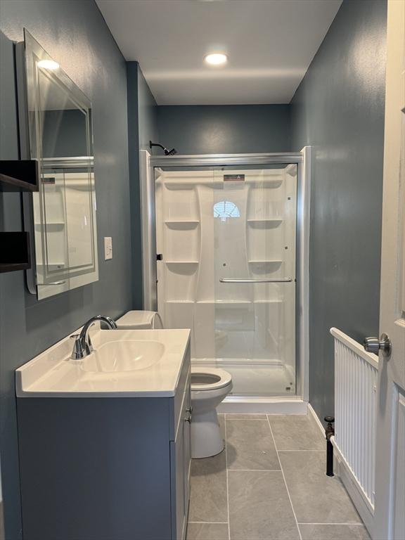 full bathroom with toilet, a shower stall, tile patterned flooring, and vanity