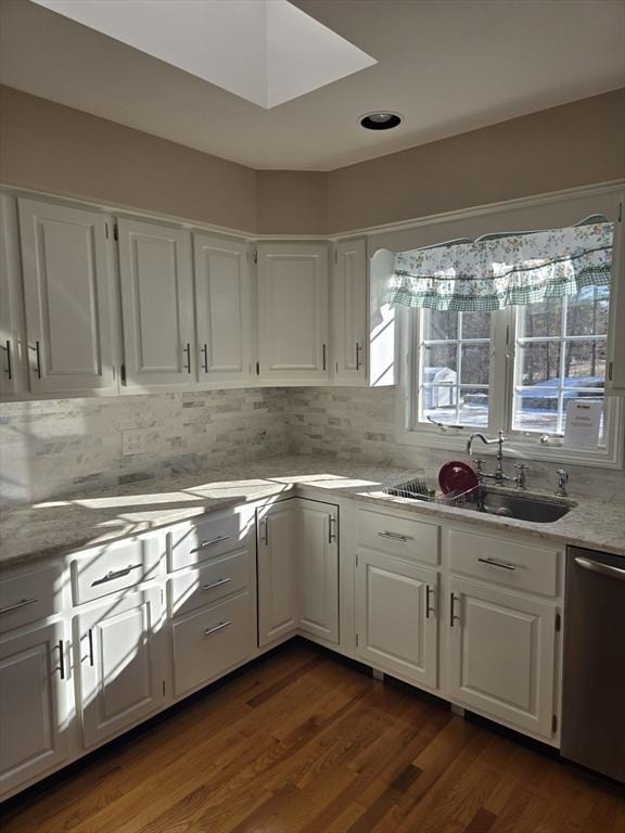 kitchen featuring dishwasher, white cabinetry, and sink