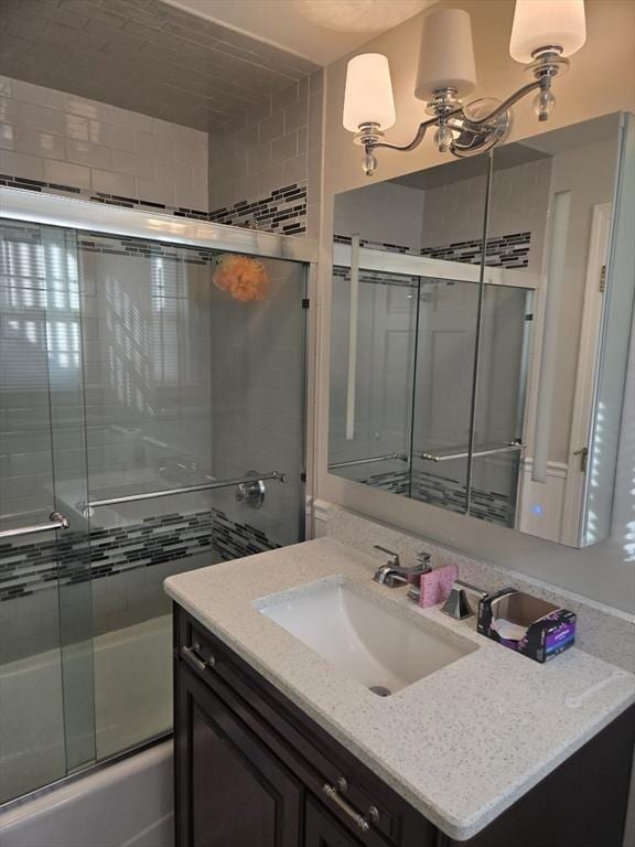 bathroom featuring vanity and bath / shower combo with glass door