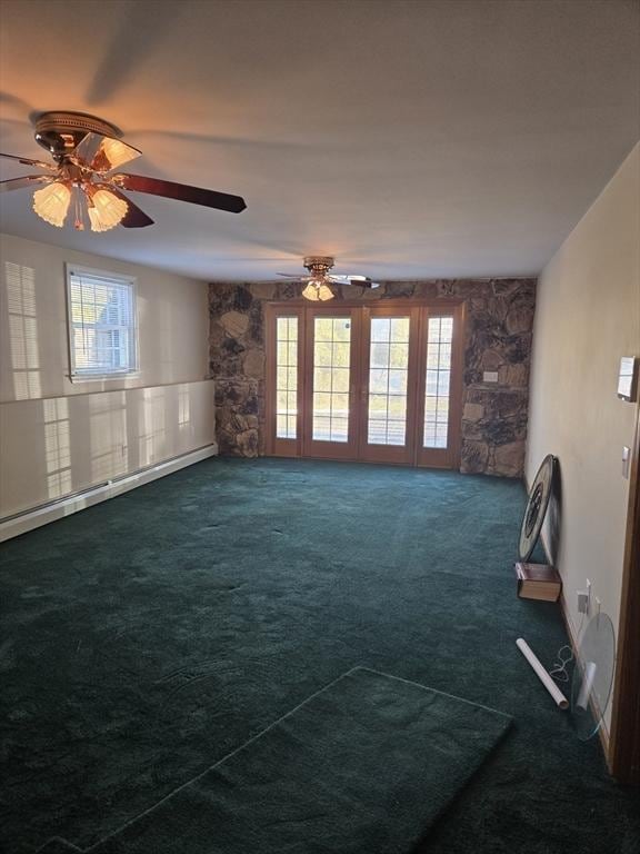 carpeted empty room with baseboard heating and ceiling fan