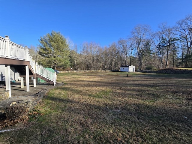 view of yard featuring a shed and a wooden deck