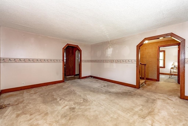 carpeted empty room with a textured ceiling