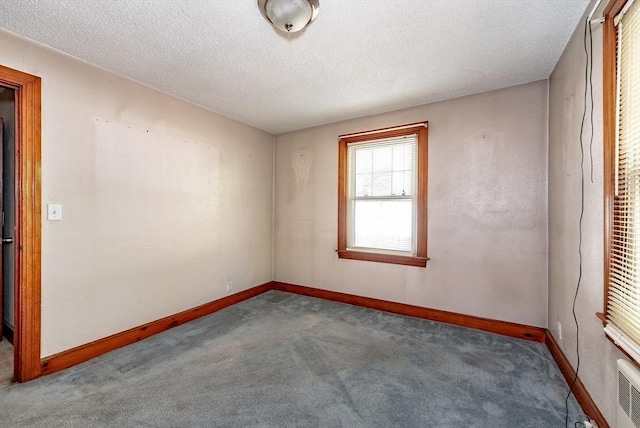 carpeted spare room with a textured ceiling