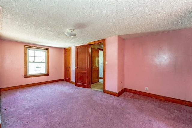 empty room featuring a textured ceiling and light carpet