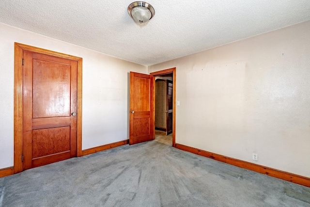 carpeted spare room featuring a textured ceiling