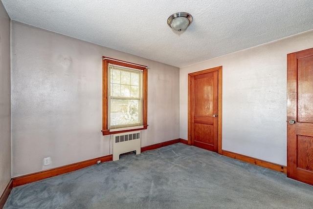 unfurnished room with radiator, light carpet, and a textured ceiling