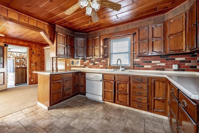 kitchen with wooden ceiling, carpet floors, sink, wooden walls, and kitchen peninsula