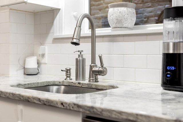 37 Grove St Unit 2, Boston, MA 02114 - kitchen view of a sink, decorative backsplash, light stone countertops, and white cabinetry