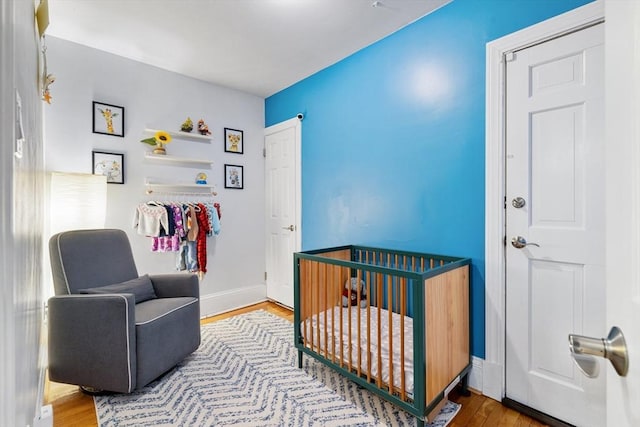 37 Grove St Unit 2, Boston, MA 02114 - bedroom with a nursery area, wood finished floors, and baseboards