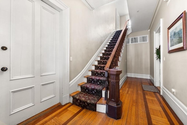 staircase featuring baseboards and wood finished floors