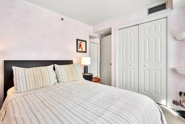 bedroom with a closet, visible vents, and carpet flooring