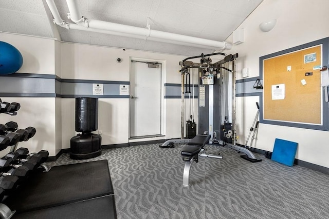 exercise room featuring carpet flooring and baseboards