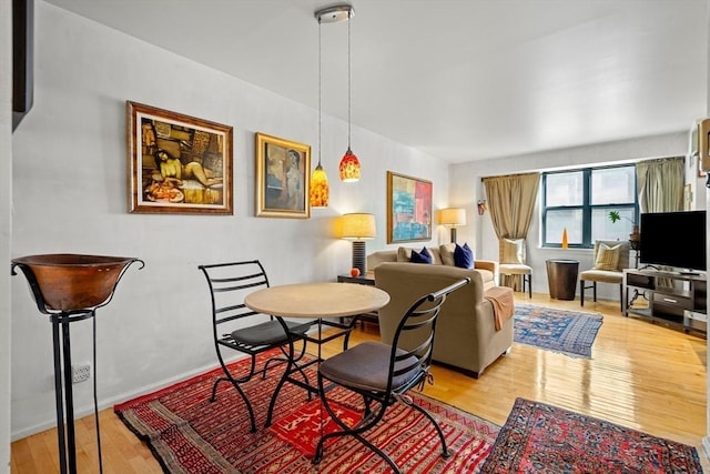 dining room featuring baseboards and hardwood / wood-style flooring