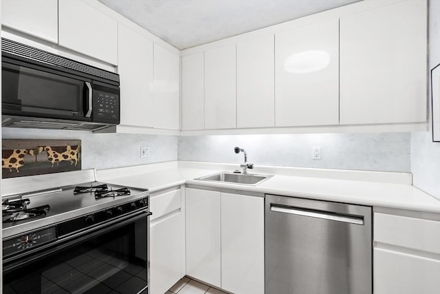 kitchen featuring black appliances, white cabinets, light countertops, and a sink