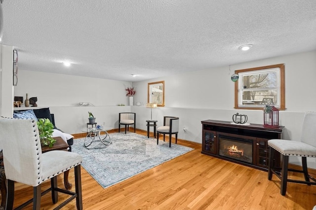 sitting room featuring light hardwood / wood-style floors and a textured ceiling