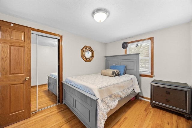 bedroom with light hardwood / wood-style floors and a closet