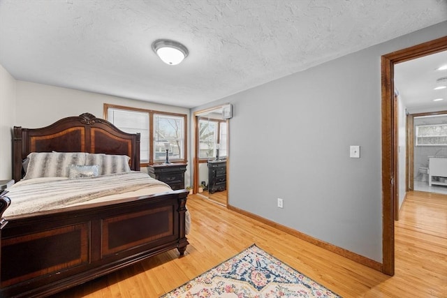 bedroom featuring light hardwood / wood-style floors and a textured ceiling