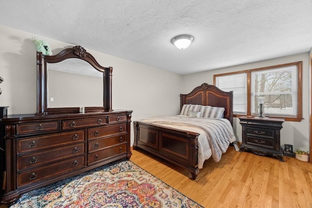 bedroom featuring light hardwood / wood-style floors and a textured ceiling