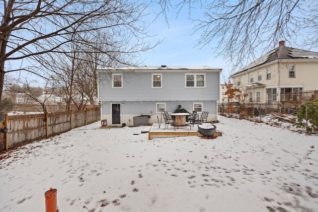 snow covered house with a wooden deck