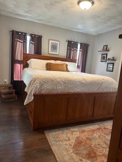 bedroom featuring a textured ceiling and dark hardwood / wood-style floors