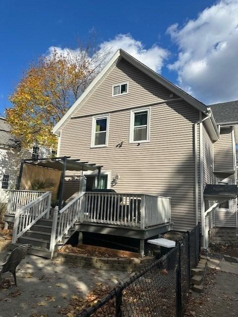 rear view of house with a pergola and a deck