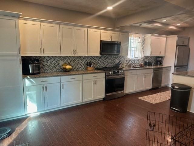 kitchen featuring dark hardwood / wood-style floors, white cabinetry, backsplash, and appliances with stainless steel finishes