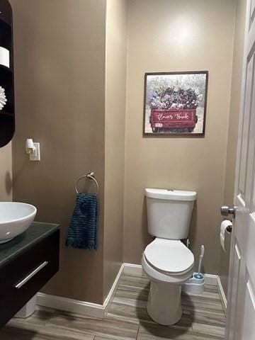 bathroom featuring toilet, sink, and hardwood / wood-style flooring