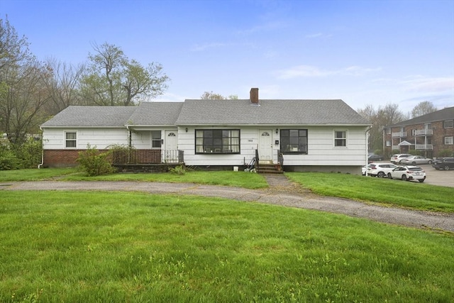 ranch-style house with a chimney and a front yard
