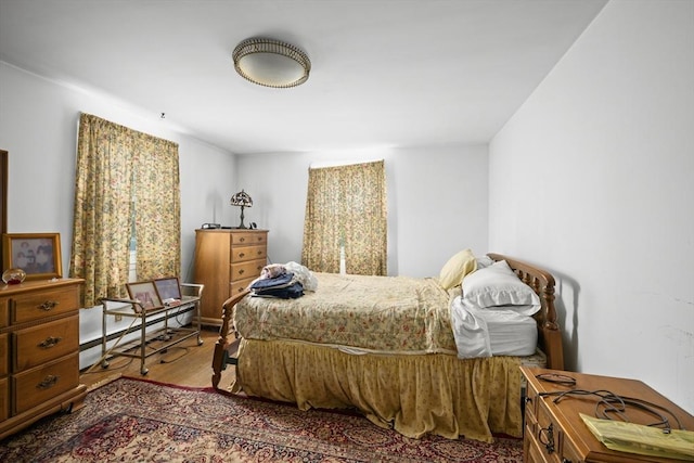 bedroom with wood finished floors and baseboard heating