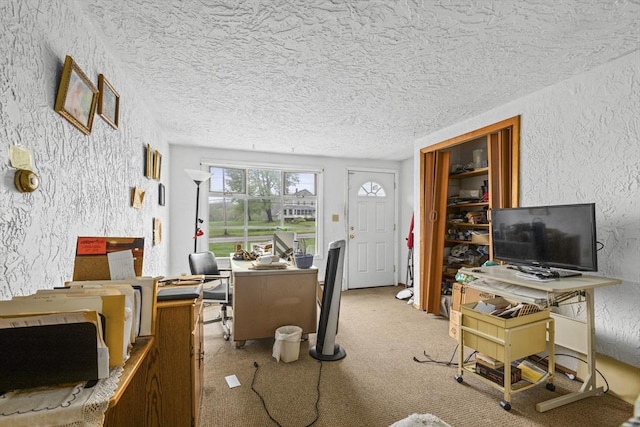 living area featuring a desk, a textured wall, and a textured ceiling