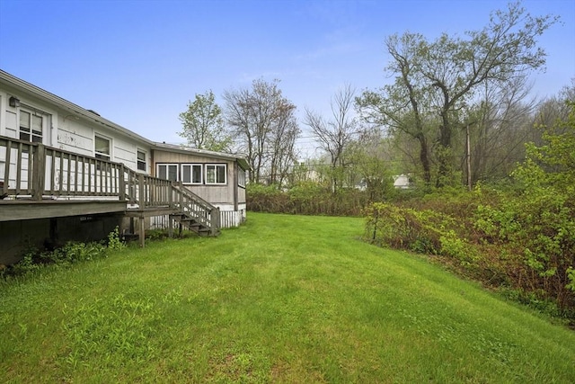 view of grassy yard with a deck