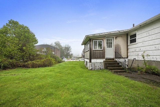 view of grassy yard featuring entry steps