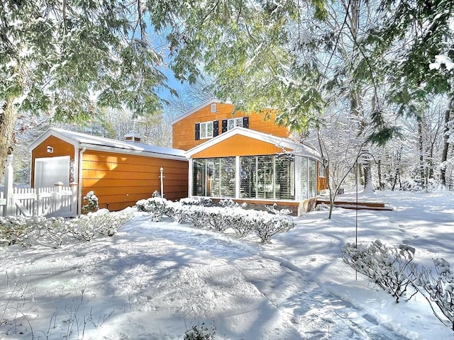 view of front of property featuring a garage and a sunroom