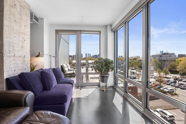 living area with a view of city, visible vents, and finished concrete floors