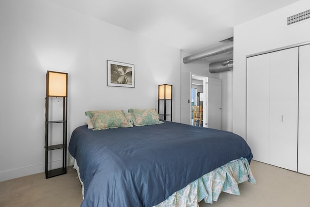 bedroom featuring carpet floors, baseboards, visible vents, and a closet