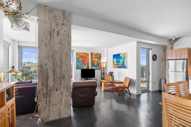 interior space with baseboards, plenty of natural light, and finished concrete floors