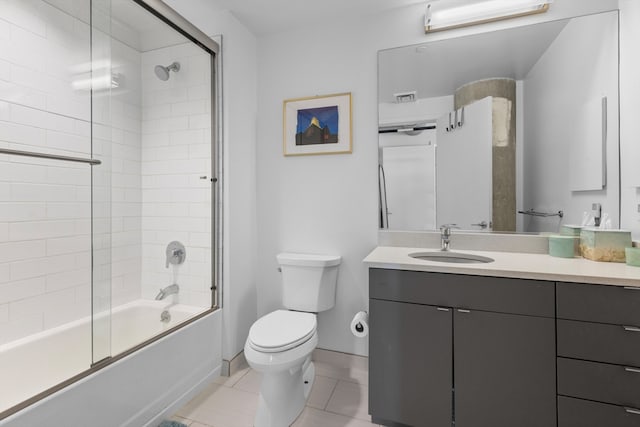 bathroom featuring tile patterned flooring, vanity, toilet, baseboards, and enclosed tub / shower combo