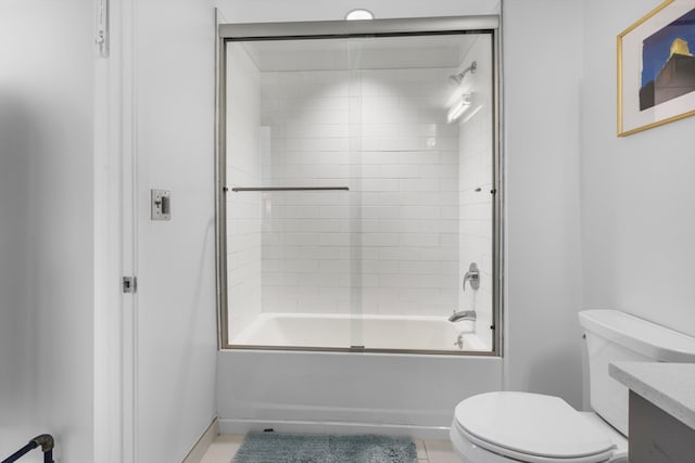 full bathroom featuring vanity, bath / shower combo with glass door, and toilet