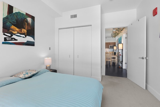 bedroom featuring visible vents, baseboards, carpet floors, and a closet