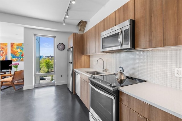kitchen with a sink, appliances with stainless steel finishes, tasteful backsplash, and light countertops