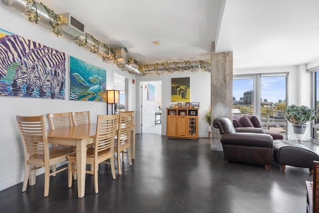dining area with visible vents, baseboards, and finished concrete floors