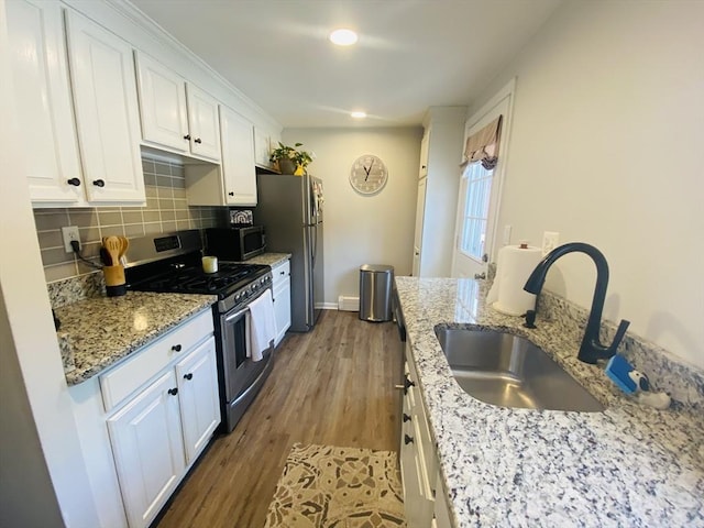 124 Kingston St Unit 124, North Andover, MA 01845 - kitchen with appliances with stainless steel finishes, white cabinetry, tasteful backsplash, wood finished floors, and recessed lighting