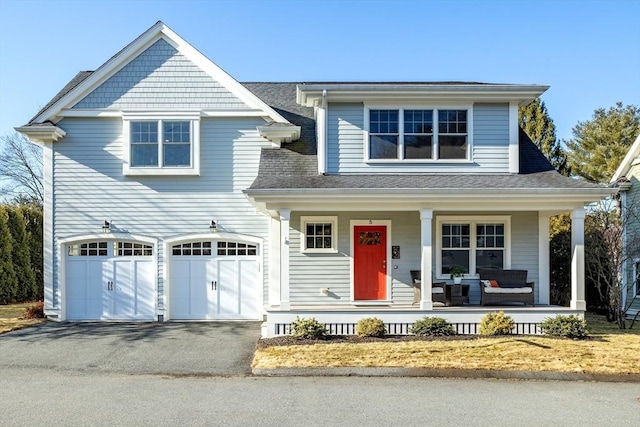 view of front of home featuring aphalt driveway, covered porch, an attached garage, and roof with shingles