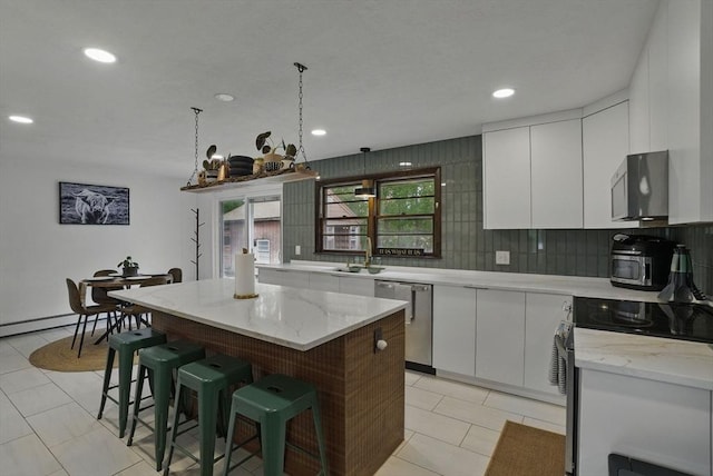 735 Union St, Leominster, MA 01453 - kitchen with appliances with stainless steel finishes, a kitchen breakfast bar, white cabinets, tasteful backsplash, and a sink