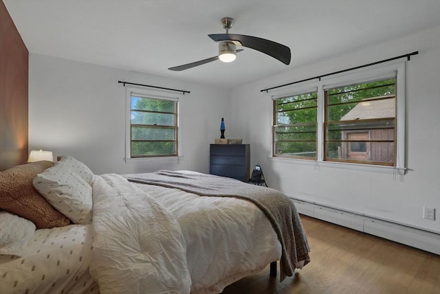 735 Union St, Leominster, MA 01453 - bedroom with baseboard heating, wood finished floors, multiple windows, and a ceiling fan