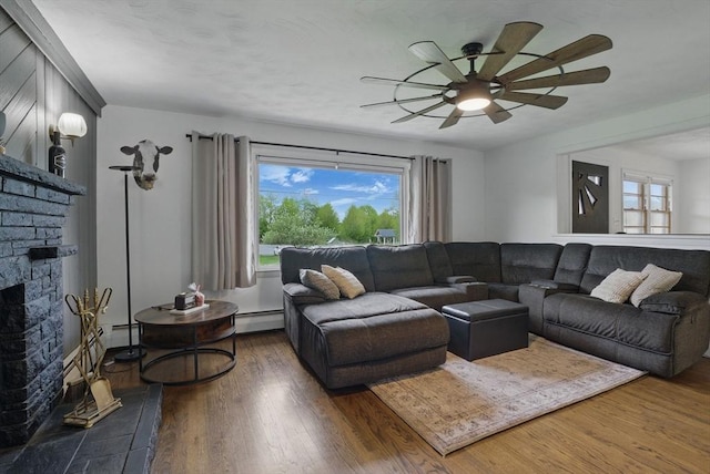 735 Union St, Leominster, MA 01453 - living area with a baseboard heating unit, healthy amount of natural light, ceiling fan, and wood finished floors
