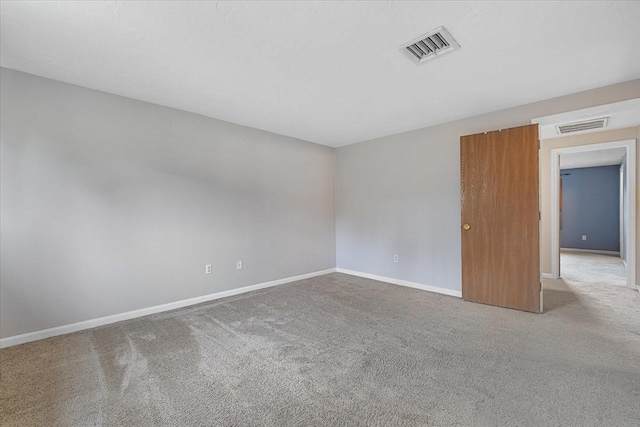 carpeted spare room featuring baseboards