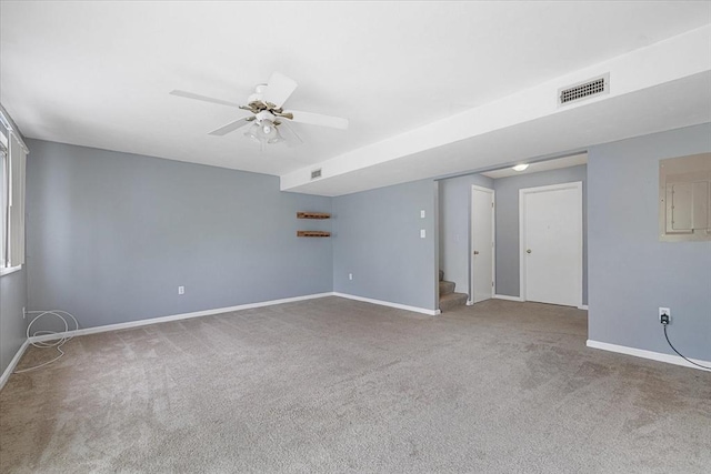 carpeted spare room featuring stairway, baseboards, and ceiling fan