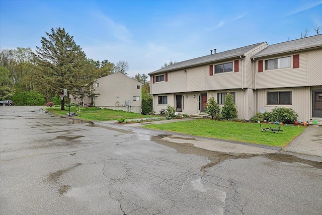townhome / multi-family property featuring a front lawn